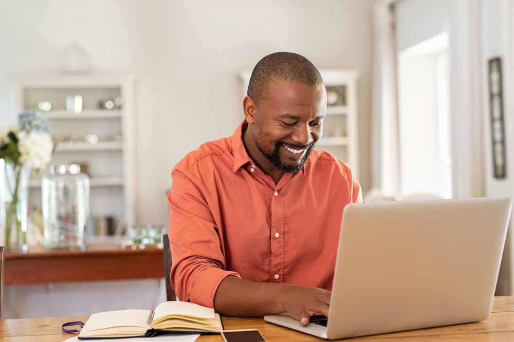 man smiling at his computer