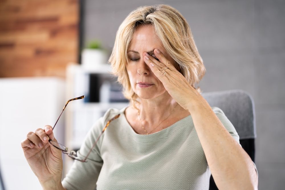 woman rubbing her eye