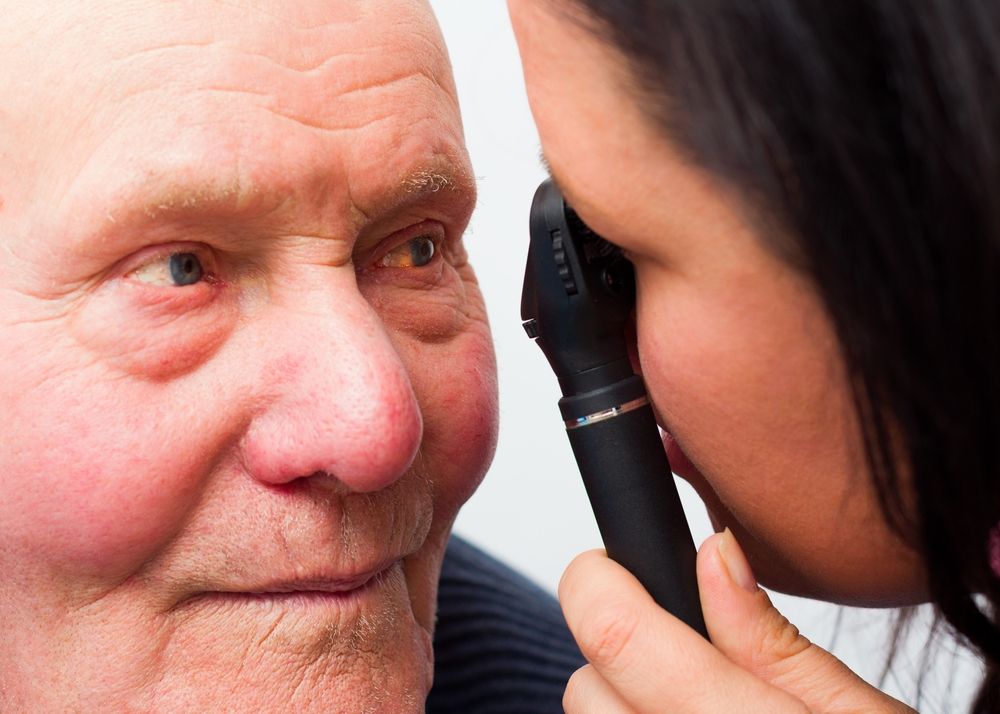 old patient having eyes checked by doctor