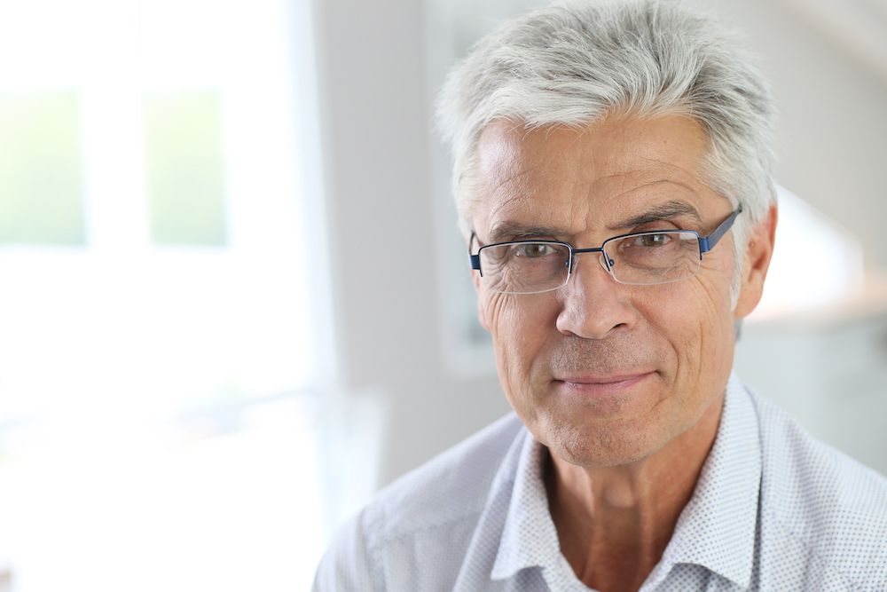 older man with silver hair and glasses
