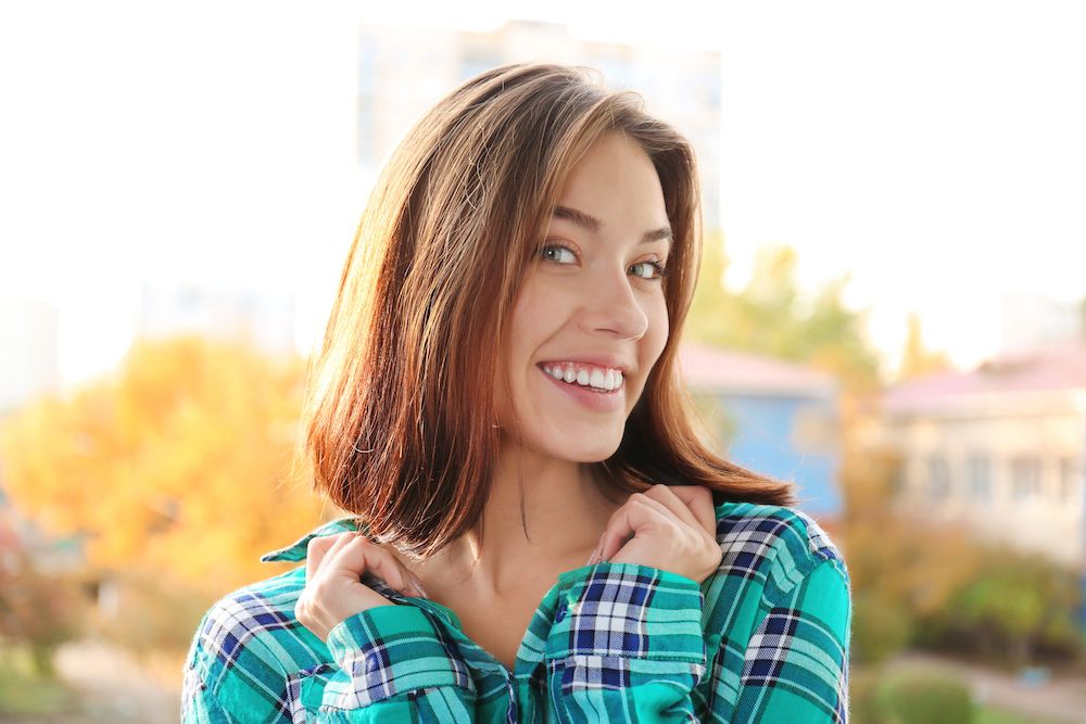 young woman in plaid shirt smiling