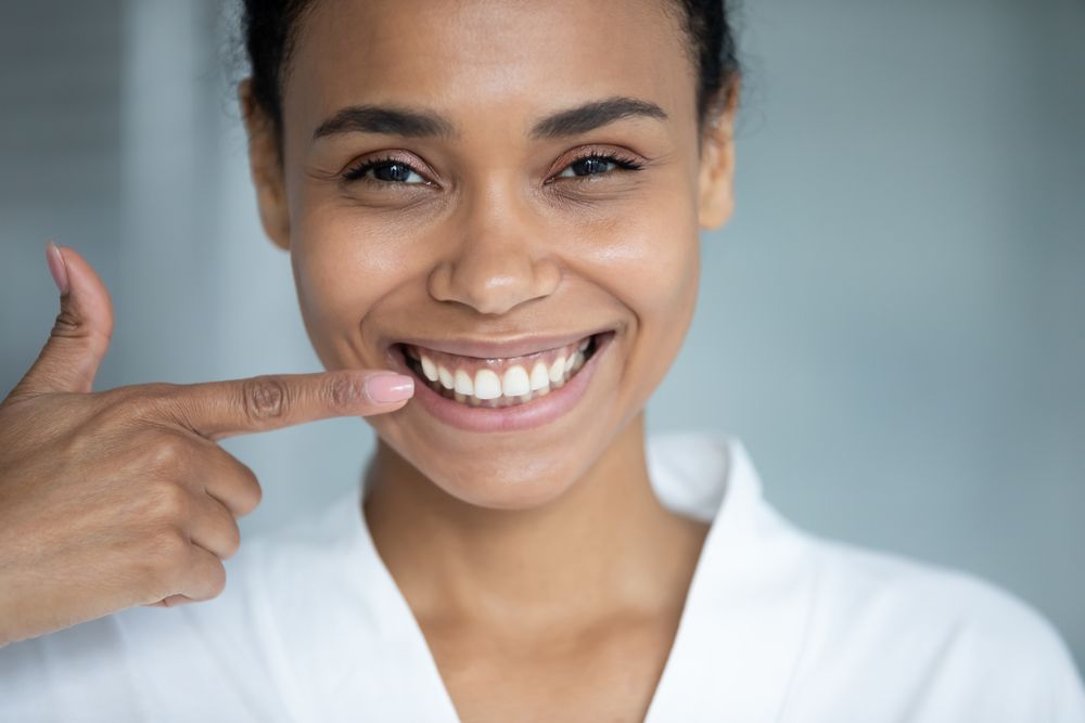 Portrait of woman pointing at her teeth