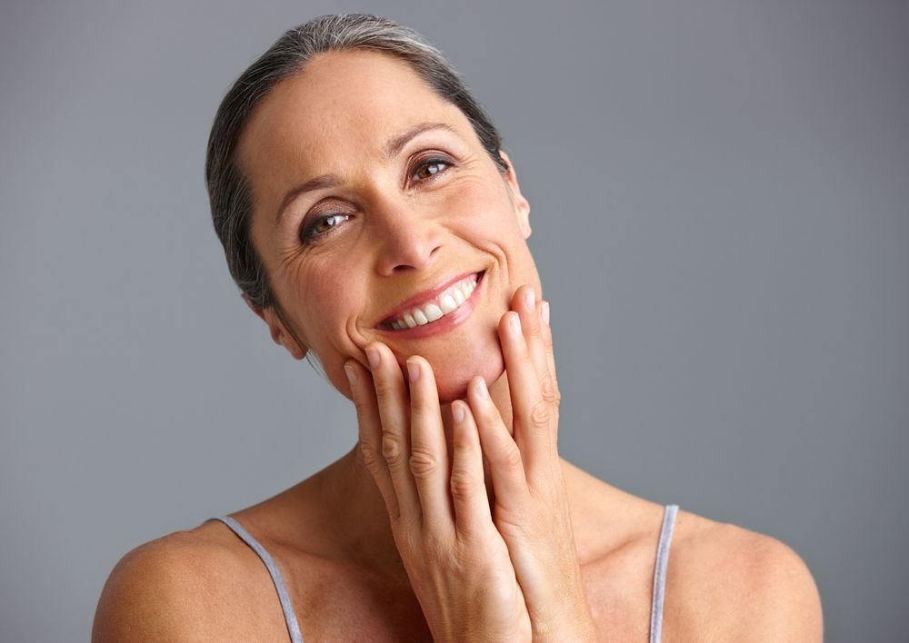 woman touching her face, clear skin​​​​​​​