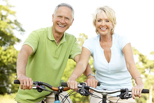 couple smiling while riding a bike