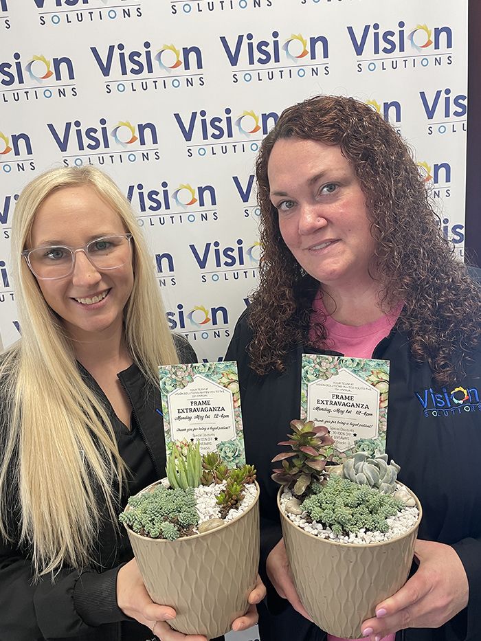 two team members holding succulents 