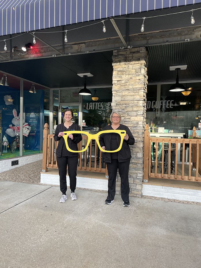 two team members holding giant glasses 