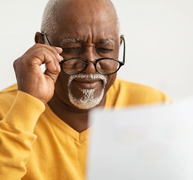 man squinting at a paper