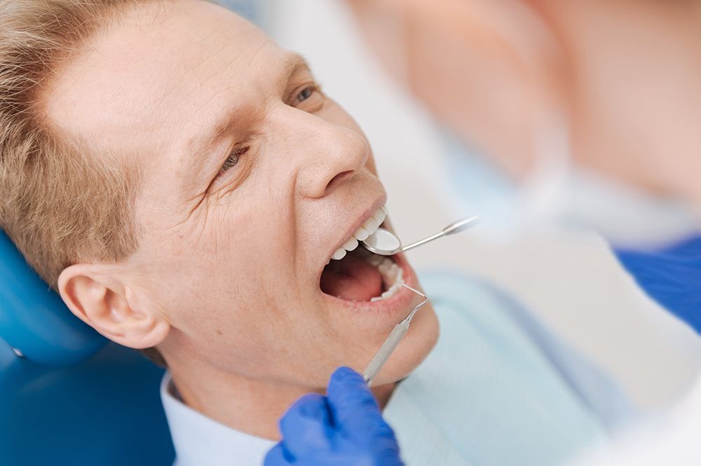 senior man getting teeth examined