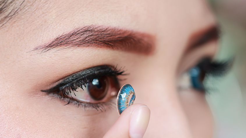 Woman putting contact lens on