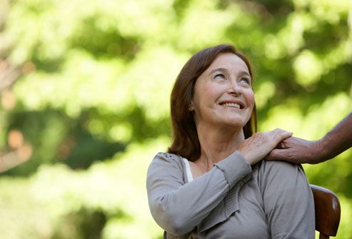 Smiling old woman while touching someone's hand