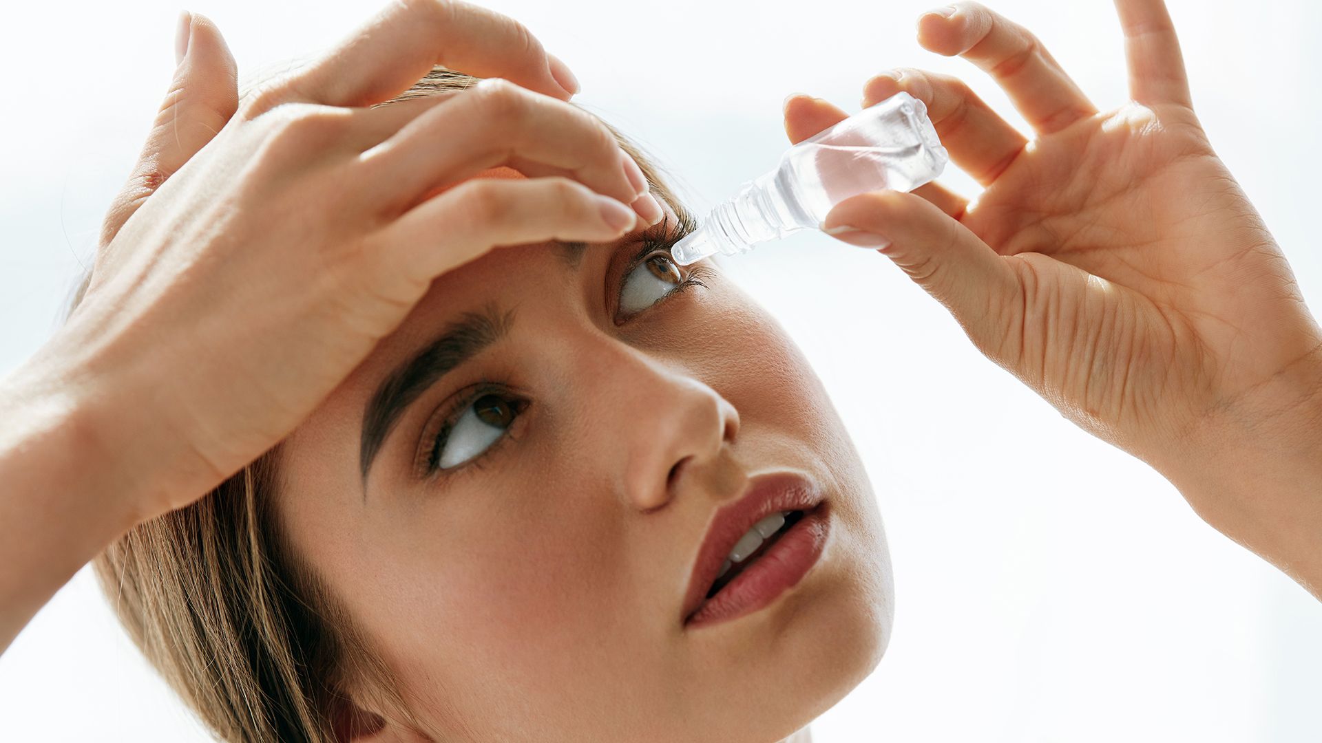 woman putting in eye drops