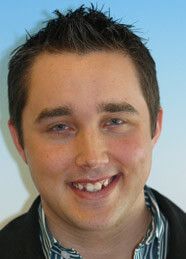 Young man smiling with straight teeth after aligner therapy