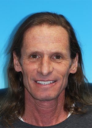 Man with a full set of new dentures smiling for the camera