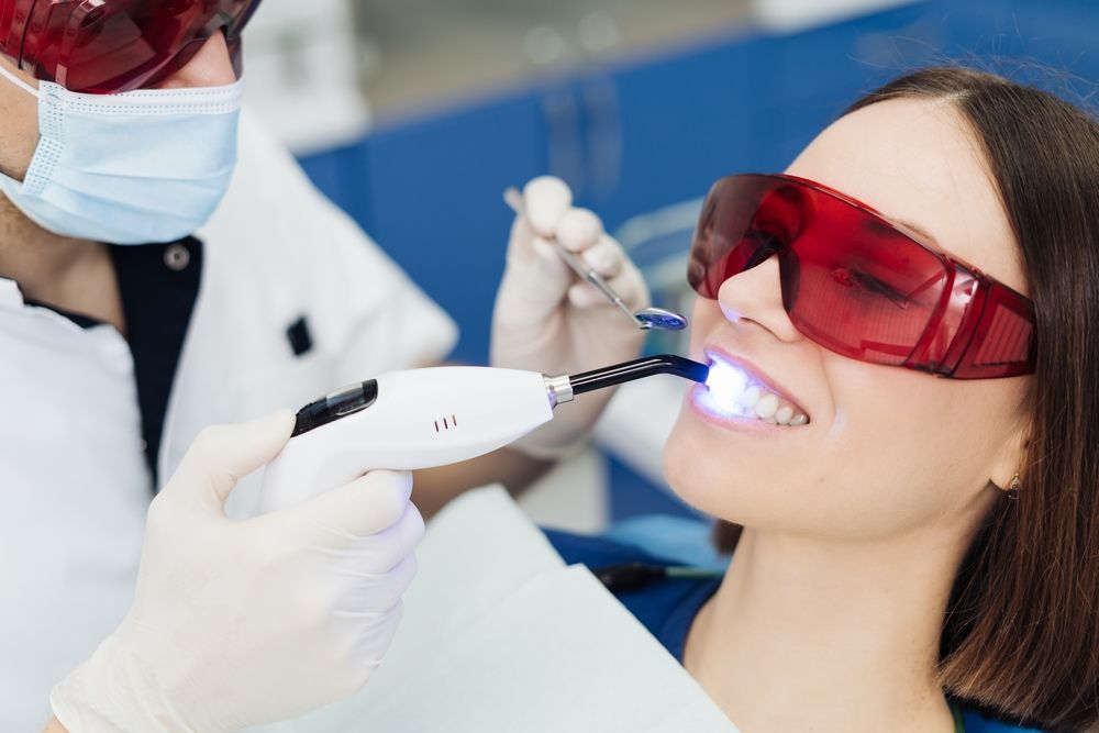 woman getting professional teeth whitening​​​​​​​