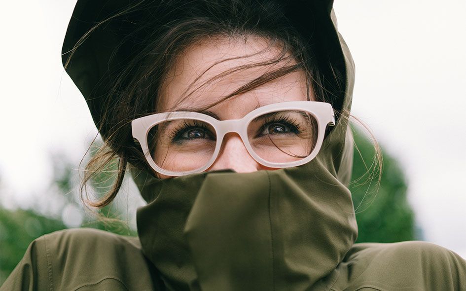 Happy girl wear her eye glasses and rain coat