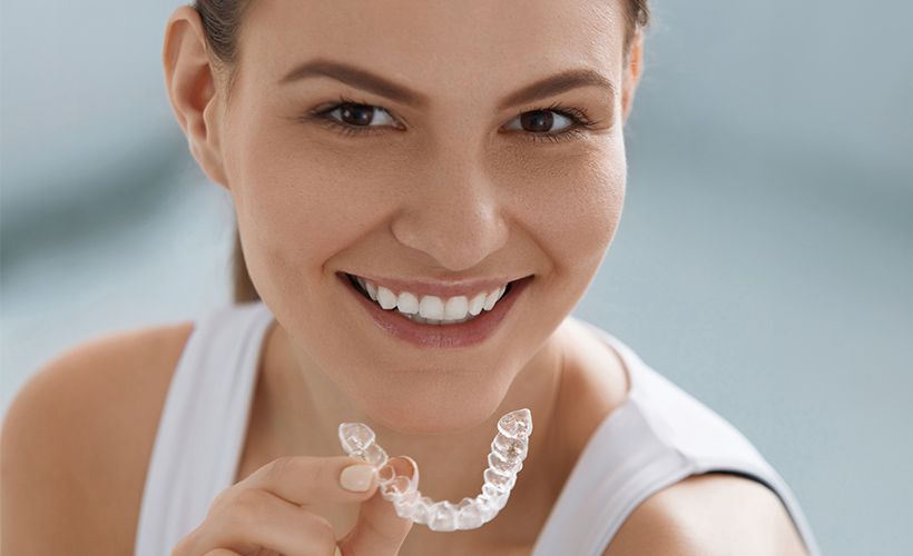 woman holding invisalign