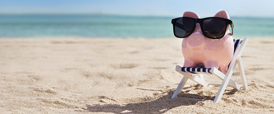 Piggy bank with sunglasses from eye doctor sitting on a chair at the beach in Tequesta, FL