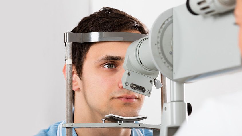 man looking into eye care technology machine