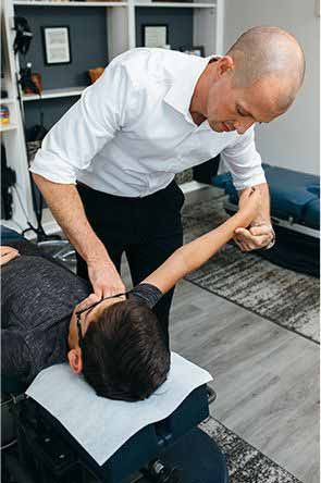 dr joe stretching out a patient's arm