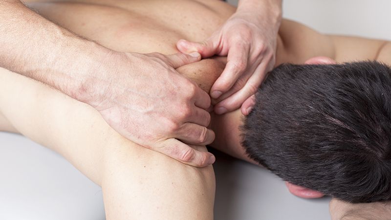 man's bare back being massaged