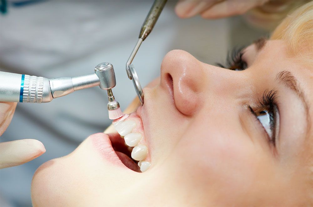 patient getting her teeth checked​​​​​​​