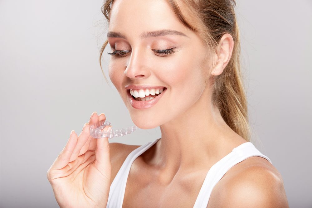 woman smiling while looking at invisalign​​​​​​​