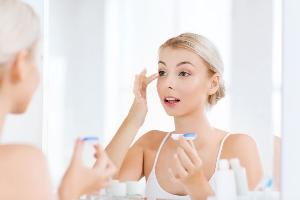 woman putting on contact lenses