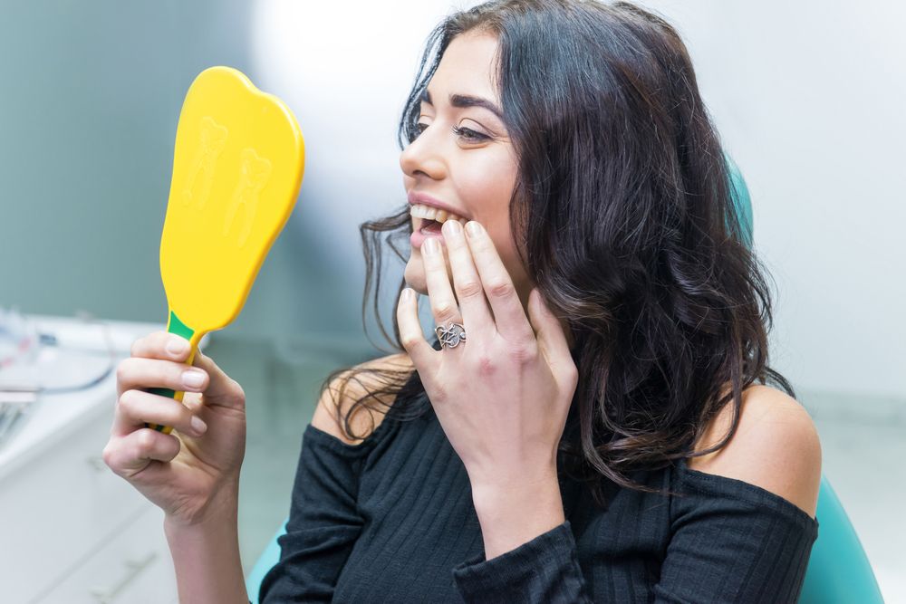 happy patient looking at her teeth