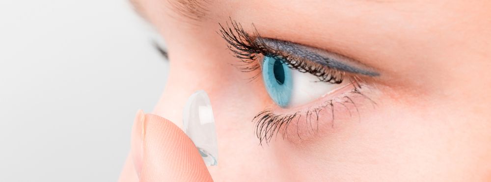 woman putting contact lens in eye