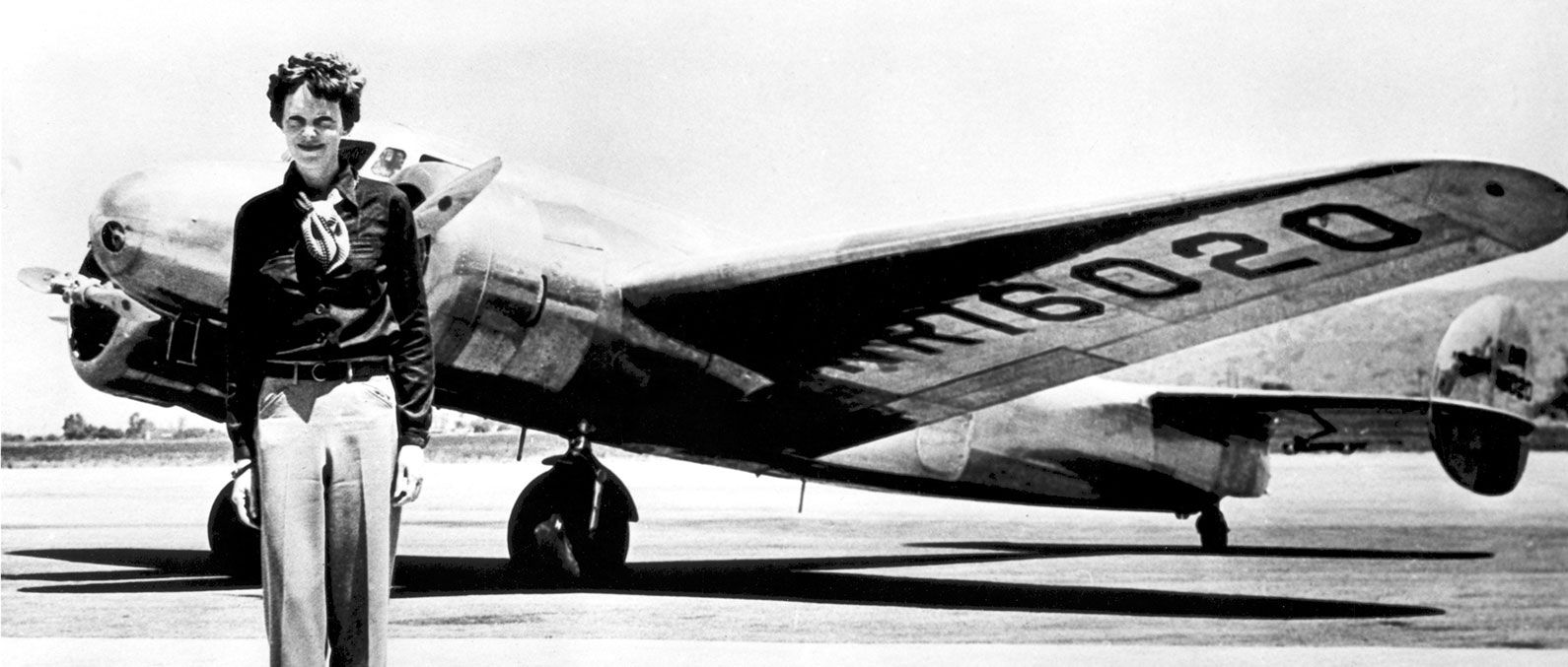 Amelia Earhart standing in front of the Lockheed Electra