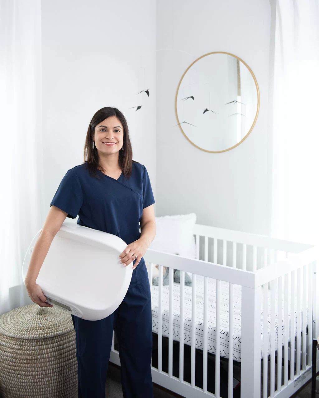woman chiropractor next to baby crib