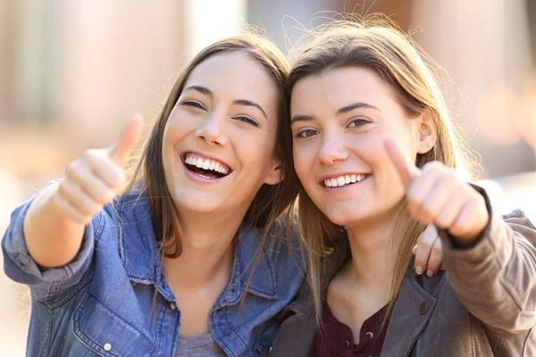 Two funny friends with thumbs up