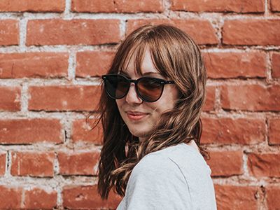 Women wearing sunglasses in front of brick wall