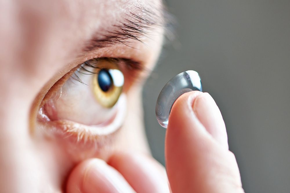 woman putting in contact lenses for astigmatism