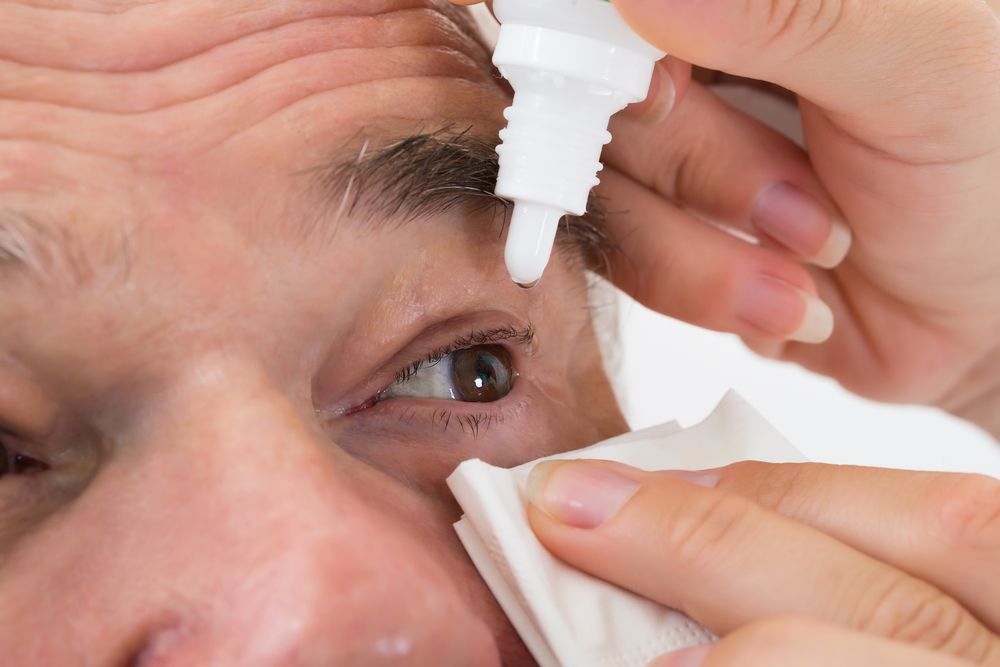 old man putting in eye drops