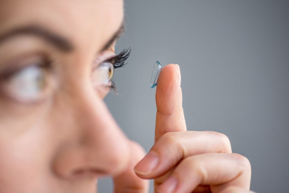 Girl put contact lenses on her eyes