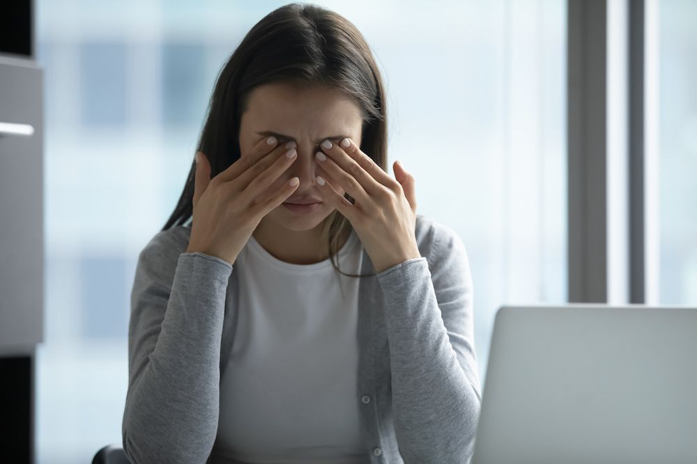 woman rubbing her eyes