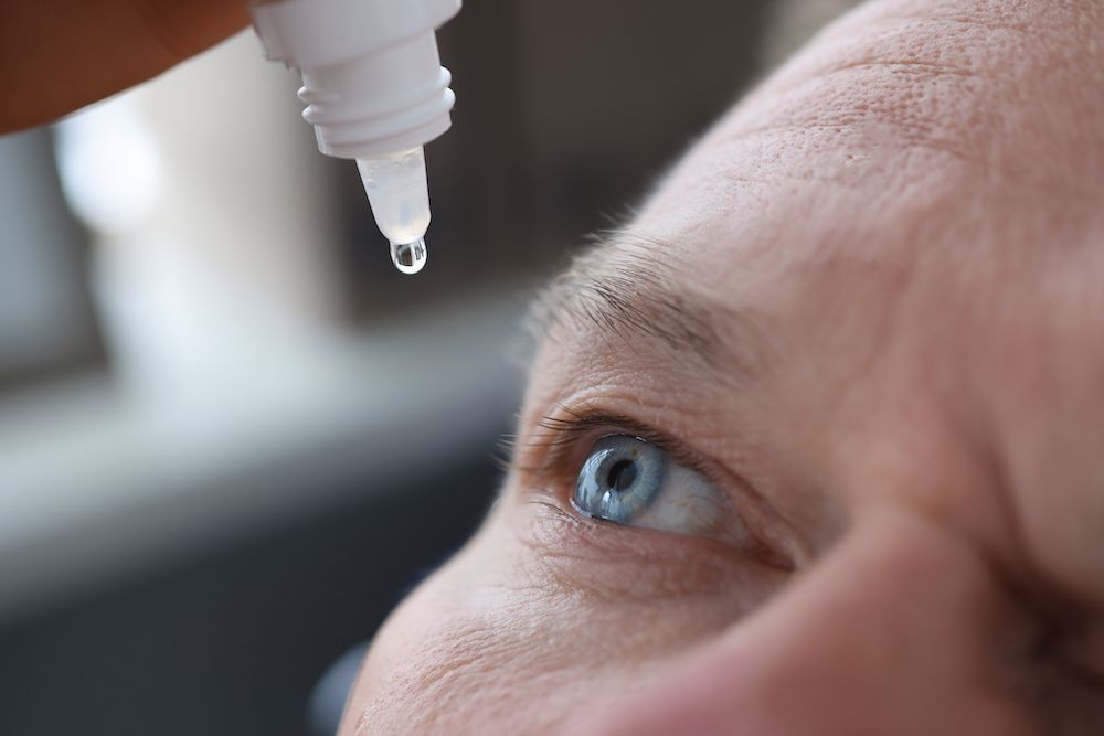 person putting in eye drops