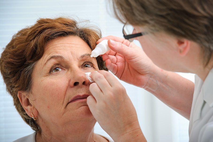 doctor putting eye drops into woman's eye