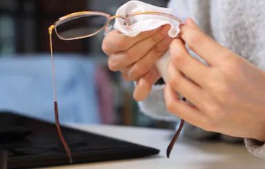 woman cleaning her glasses