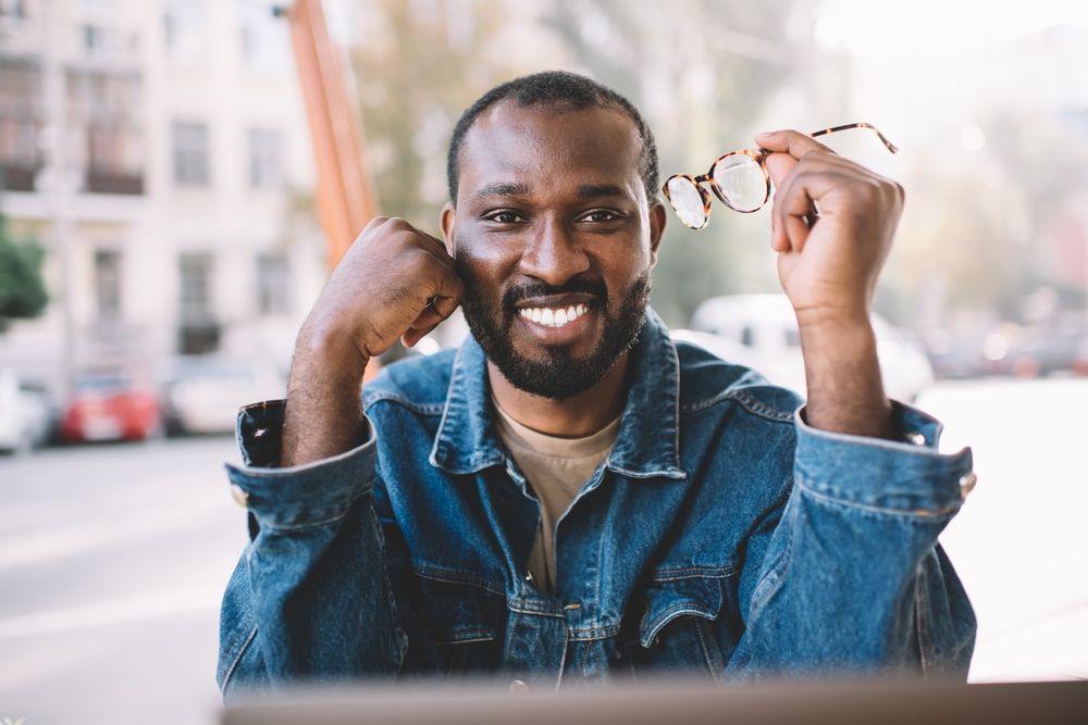 man holding glasses smiling