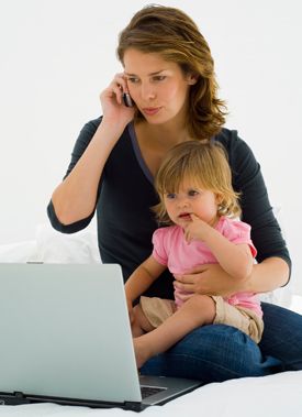 mom on the phone with a child in her arms