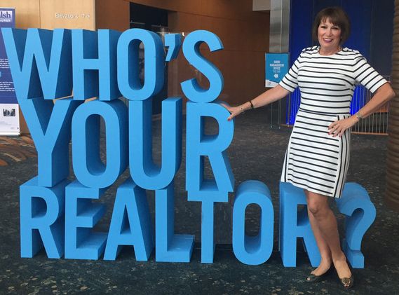 Gerri-Lynn Fives Standing Next to Who's Your Realtor Sign