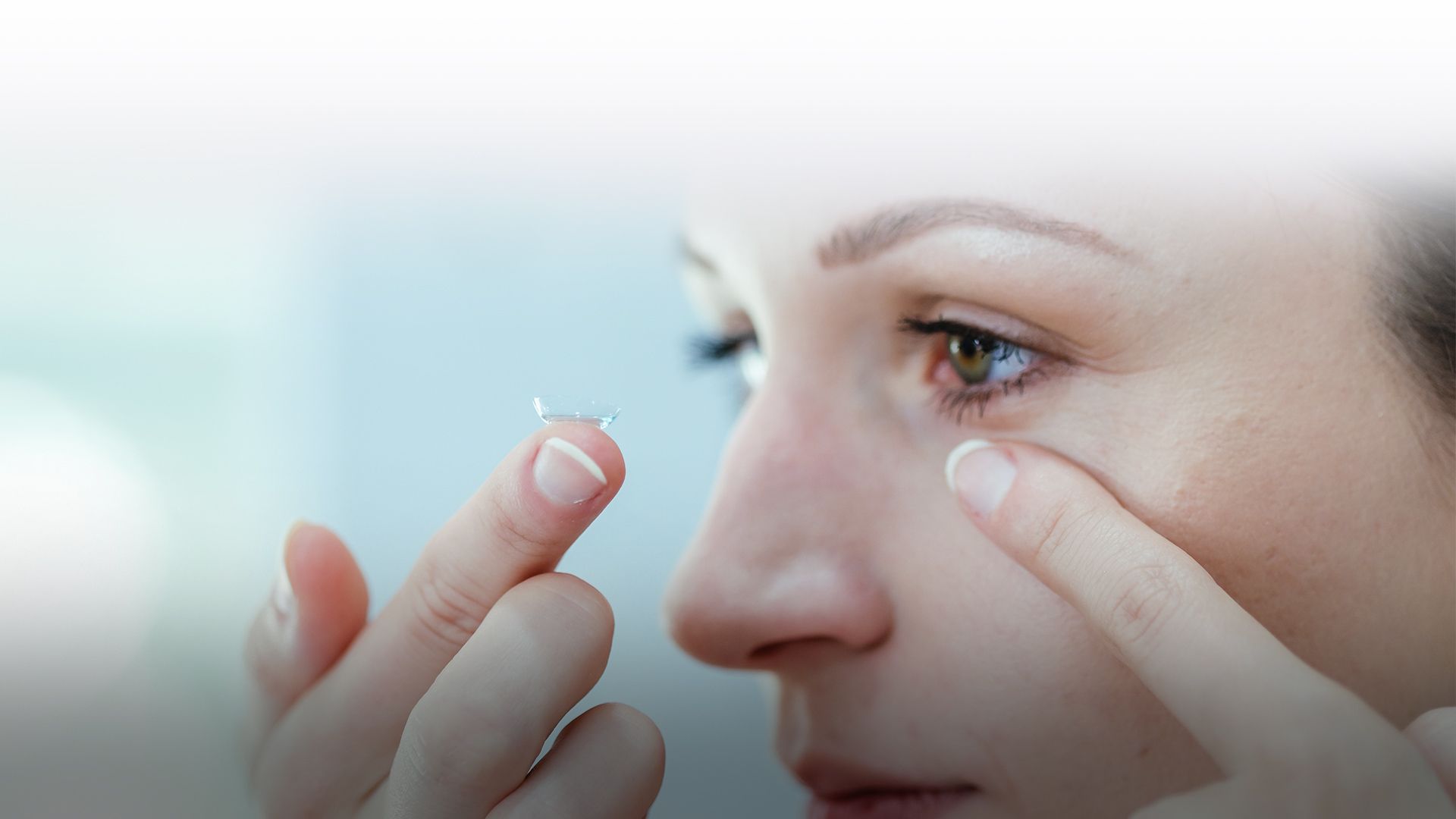 woman putting on contact lens