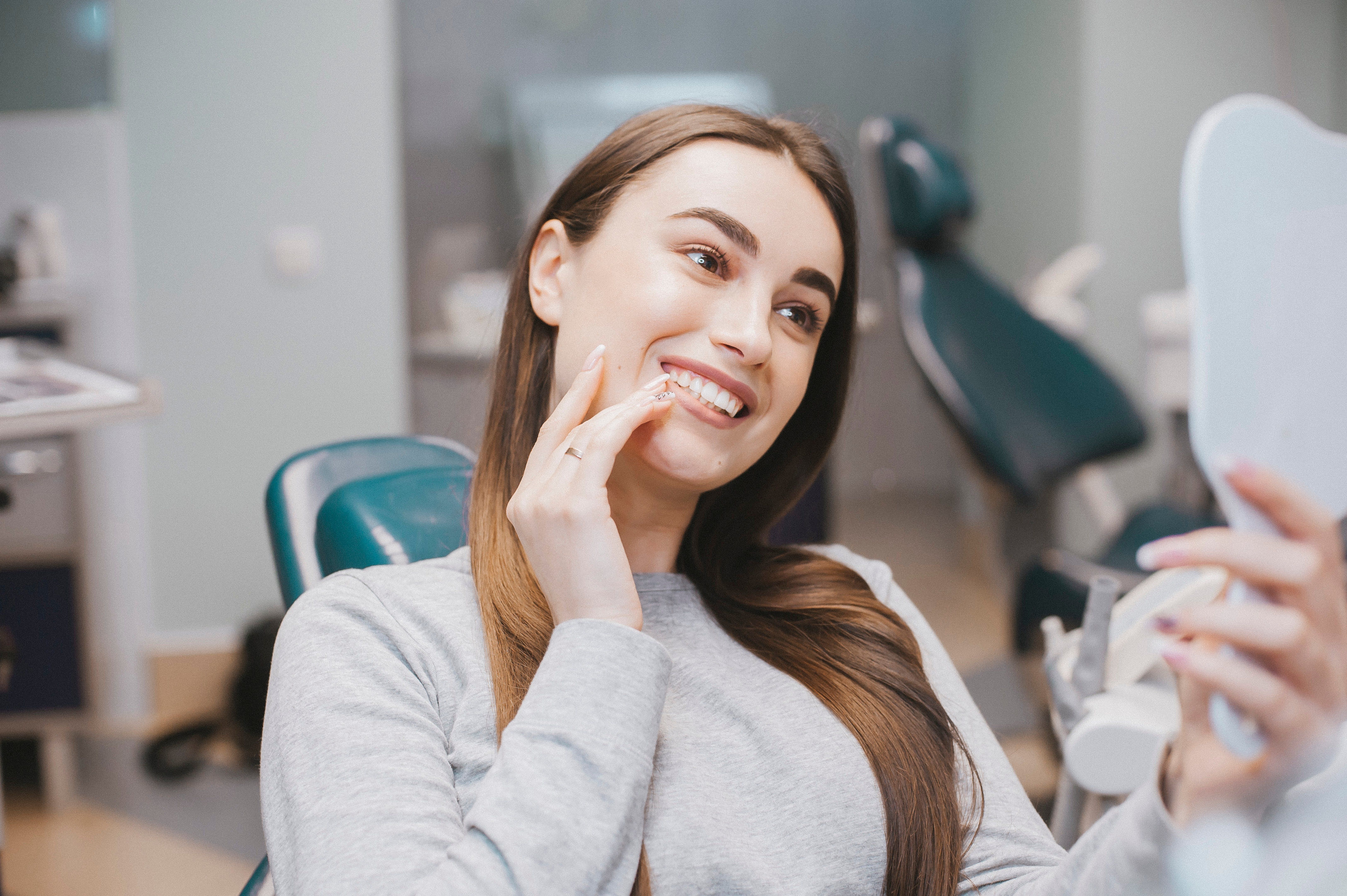 gril happy with teeth whitening in dentist office
