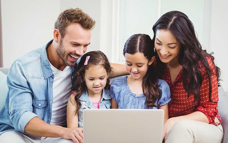 family looking at laptop