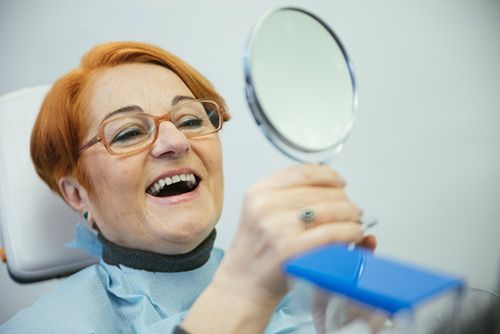 woman fondly looking at her teeth