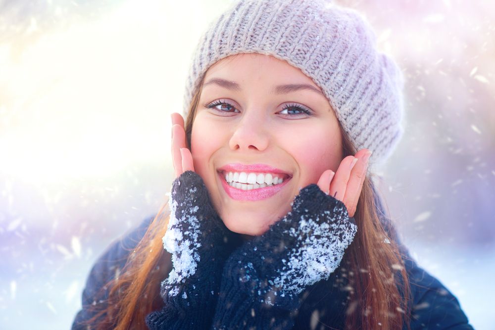 woman holding face during the winter