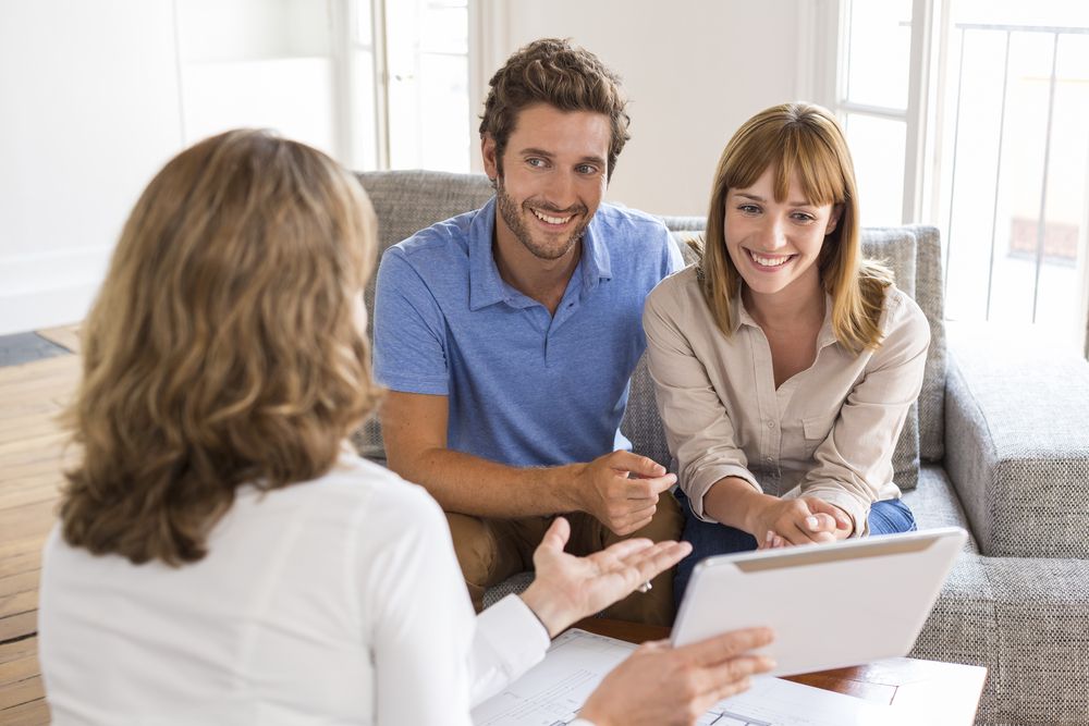 happy couple speaking with a realtor