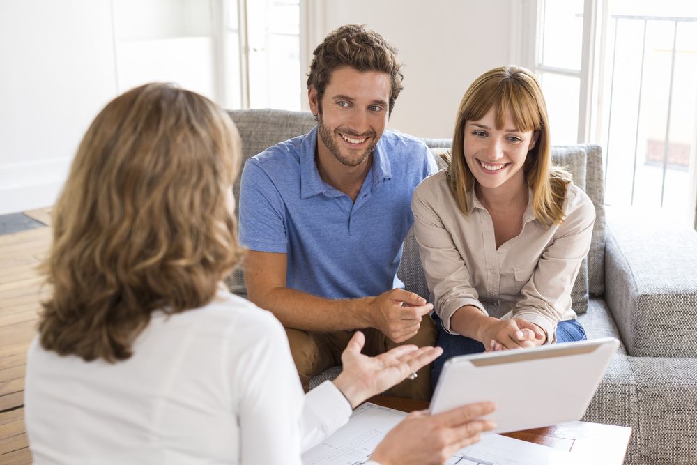 happy couple speaking with a realtor​​​​​​​